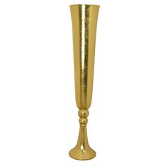 a tall gold vase sitting on top of a white table