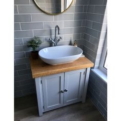 a bathroom sink sitting under a mirror next to a window