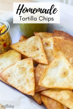 homemade tortilla chips on a plate with corn and salsa in a jar next to it