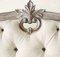 an upholstered headboard with ornate carvings on it