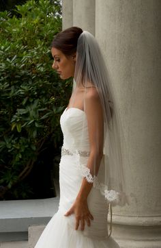 a woman in a wedding dress is standing outside