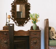 a room with a chair, mirror and table in it's centerpieces