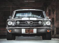 an old ford mustang sitting in a garage with the license plate on it's front