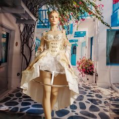 a mannequin dressed in a white and gold dress