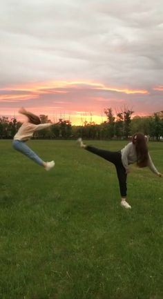 two people are doing yoga in a field at sunset with the sun setting behind them