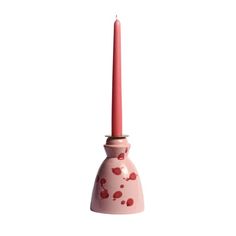 a pink candle holder with red hearts on the side and a single pillar sticking out of it