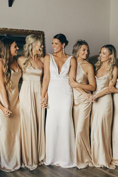 the bridesmaids are all dressed in champagne colored gowns and one is holding her hand out