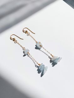 "Aquamarine is known to evoke purity of the mind, promoting calming, soothing, and cleansing energies, and inspires truth, trust, and letting go of negativity. The gemstone is also known to accelerate the intellectual reasoning processes and enhances the ability for rapid response. It makes one unconquerable through learning, not only about the physical world but about oneself. Stacks of aquamarine gemstone chips, individually hand-wrapped + 14k gold-filled dainty cable chain and earring hooks. 2 1/2\" drop length. The high quality of the gold-filled components makes them perfect for those with sensitive ears and ensures they will not turn your skin green and will never rust with proper care. No two gemstones will ever be exactly the same, therefore the piece you receive will be slightly d Gemstone Chip Earrings, Gemstone Chips Jewelry, Chip Earrings, Wire Wrapped Jewelry Diy, Aquamarine Gemstone, Earring Hooks, Jewelry Inspo, Wire Wrapped Jewelry, The Mind