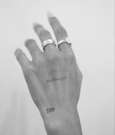 a person's left hand with two rings on it and the word love written in cursive writing