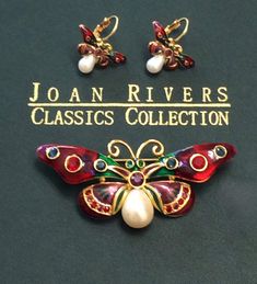 This is a vintage preowned signed Joan Rivers brooch and earrings set.  This gold tone set comes from the Joan Rivers Classic Collection and is called "Jeweled Rainbow Butterfly". The set features epoxy enamel in beautiful colors of red, green and purple with matching rhinestone colors.  Each butterfly has a faux pearl body. The large brooch measures 1.25" long x 2 7/8" wide and has a secure roll over clasp. The lever back earrings measure 1" long x 1" wide. This exquisite collectible set is in beautiful condition and will make a wonderful addition to your Joan Rivers accessories. Thank you for looking! FAST & FREE SHIPPING! Please remember this is a vintage item and as with all vintage jewelry, there will be some age related natural wear and tear. Be aware you are not buying a pristine br Joan Rivers Jewelry, Rainbow Butterfly, Joan Rivers, Butterfly Brooch, Classic Collection, Vintage Wear, Remember This, Earrings Set, Green And Purple