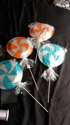 candy lollipops wrapped in cellophane and sitting on a black background