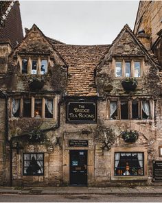 an old stone building with windows and plants on the outside