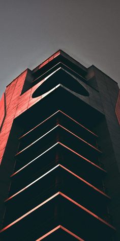 a very tall building with a clock on the top of it's face in front of a gray sky