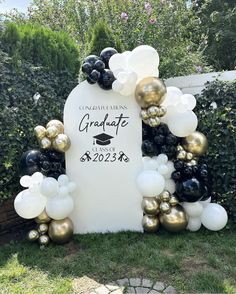 graduation balloon arch with black, white and gold balloons in the shape of an arch