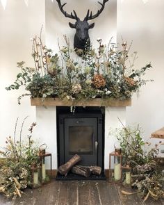 the fireplace is decorated with greenery and deer heads