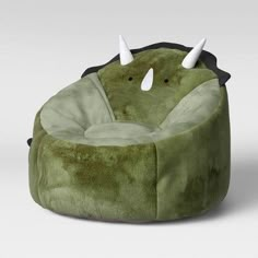 a green bean bag chair with horns on the top and two white horns sticking out of it