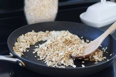 a pan filled with oats and a wooden spoon