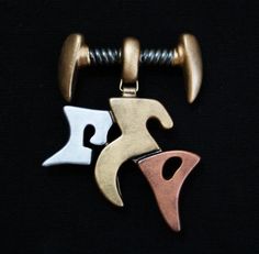 two pendants with different shapes and colors on a black background, one is gold, the other is silver