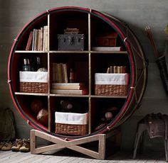 a wine barrel shelf with baskets and books on it