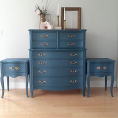 a blue dresser sitting next to a mirror on top of a wooden floor