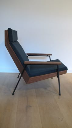 a chair sitting on top of a hard wood floor next to a white wall in an empty room