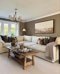 a living room filled with lots of furniture and pillows on top of a wooden coffee table