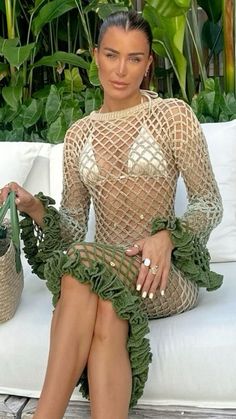 a woman sitting on top of a white couch next to a potted plant in her hand