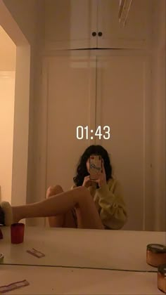 a woman taking a selfie in front of a mirror with her legs spread out