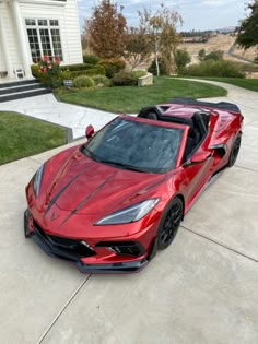 a red sports car parked in front of a house