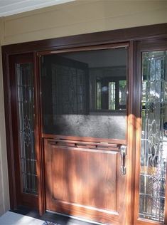 a wooden front door with glass panels