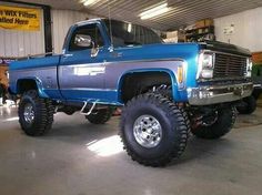 a large blue truck parked in a garage