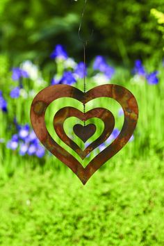 a metal heart hanging in the grass