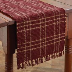 a red and white plaid table runner on a wooden table