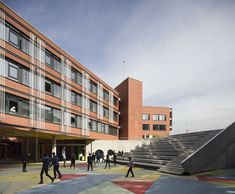 people are walking around in front of a building with stairs and steps leading up to it