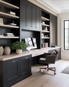 a home office with built - in bookcases, desk and chair