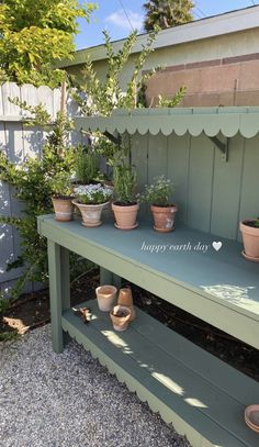 several potted plants sit on a bench in the back yard, with happy earth shop written on it