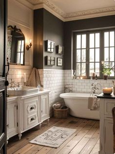 a bathroom with white and black walls, wooden floors and an old fashioned bathtub