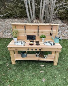 an outdoor potting station with pots and pans on the outside, surrounded by grass