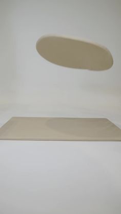 a white table with a round object on it's surface in front of the camera