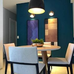 a dining room with blue walls and white chairs