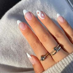 a woman's hand with white and pink manies on it, wearing a ring