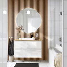 a bathroom with a sink, mirror and bathtub next to a wall mounted shower head