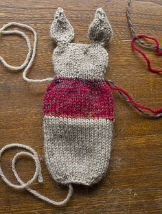 a knitted bag sitting on top of a wooden table next to a pair of scissors