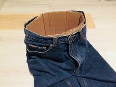 a pair of blue jeans sitting on top of a wooden floor