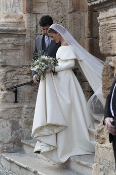 the bride and groom are walking down the stairs