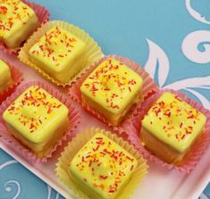 there are many small squares of yellow cake on the plate with sprinkles