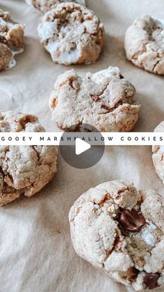 cookies with chocolate chips and powdered sugar are on top of parchment paper, next to the words gooey marshmallow cookies