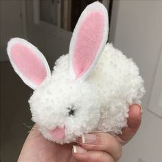 a person holding a stuffed animal in their left hand and wearing bunny ears on it's head