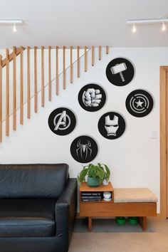 a living room filled with black furniture and wall art above a wooden coffee table on top of a hard wood floor