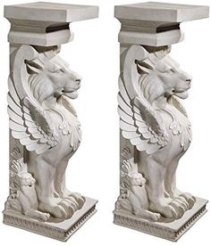 a pair of white marble lions on pedestals